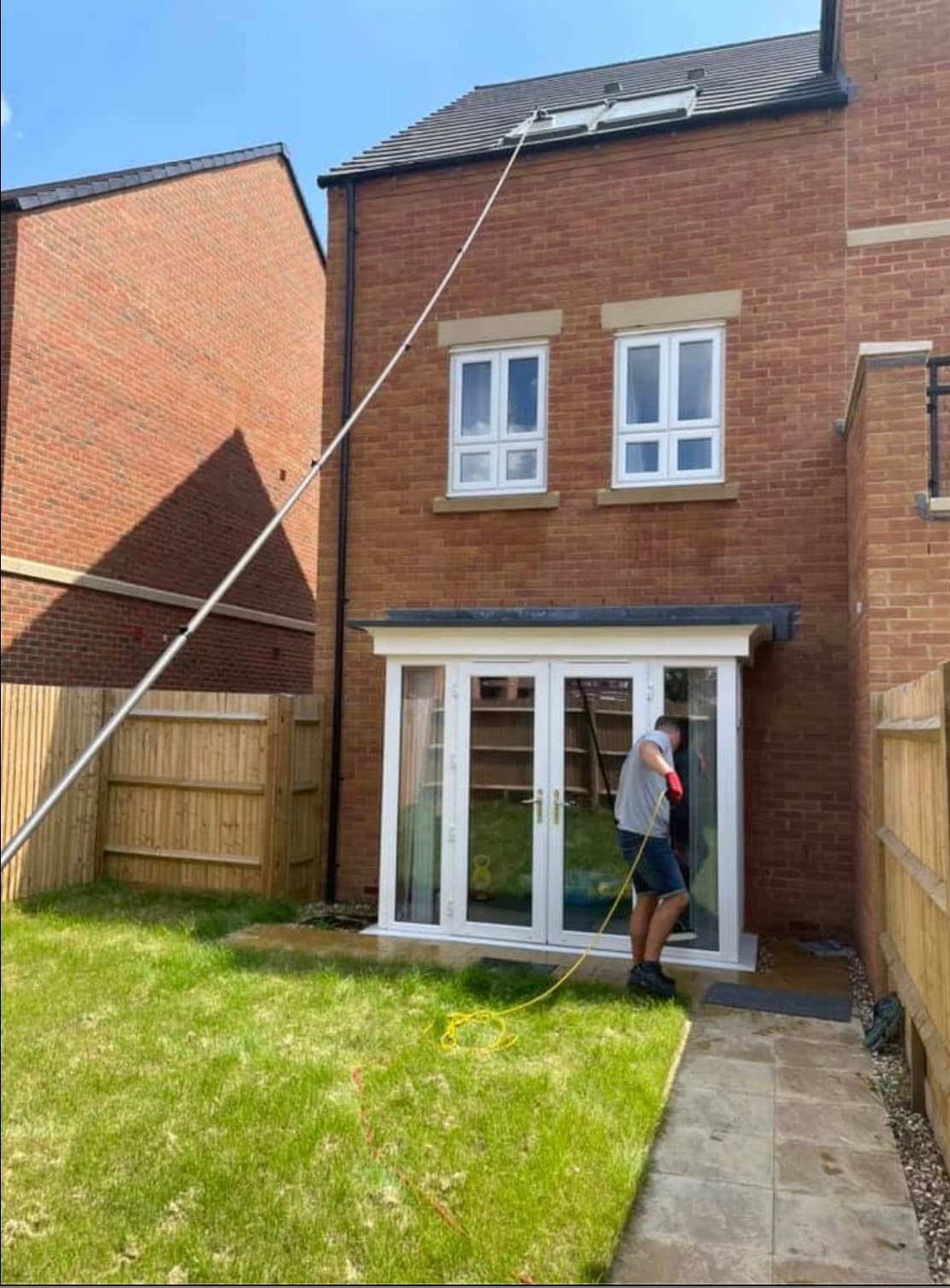 High-level windows being cleaned safely with a water-fed pole at a local home